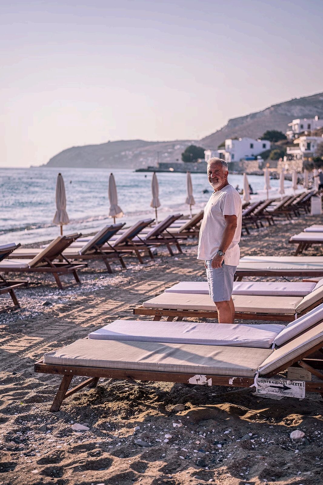 Strandoperatör hanterar bokningar i Booksunbed Studio på en surfplatta
